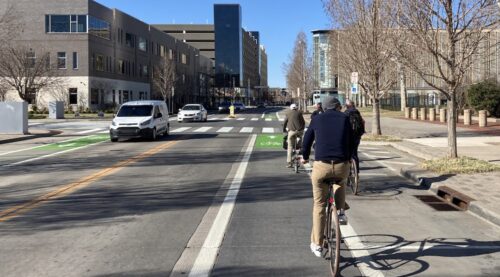 People ride bikes on street in bike lane